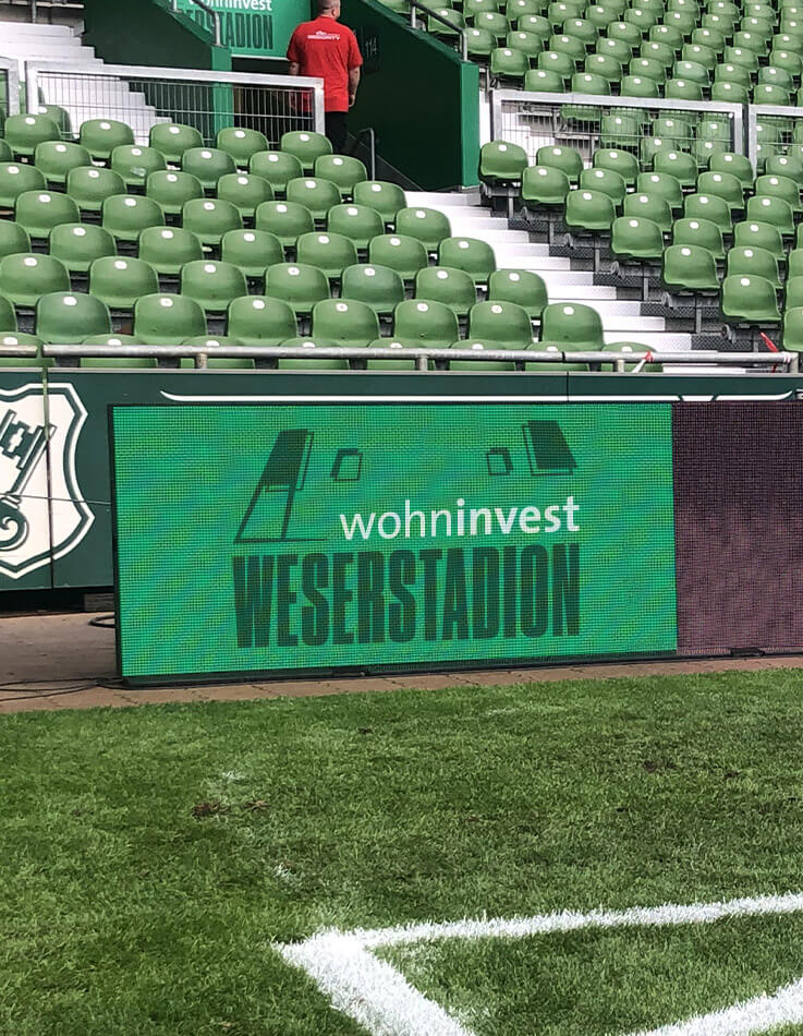 Dieses Bild zeigt die LED-Bande an der Ecke des Spielfelds im wohninvest WESERSTADION.