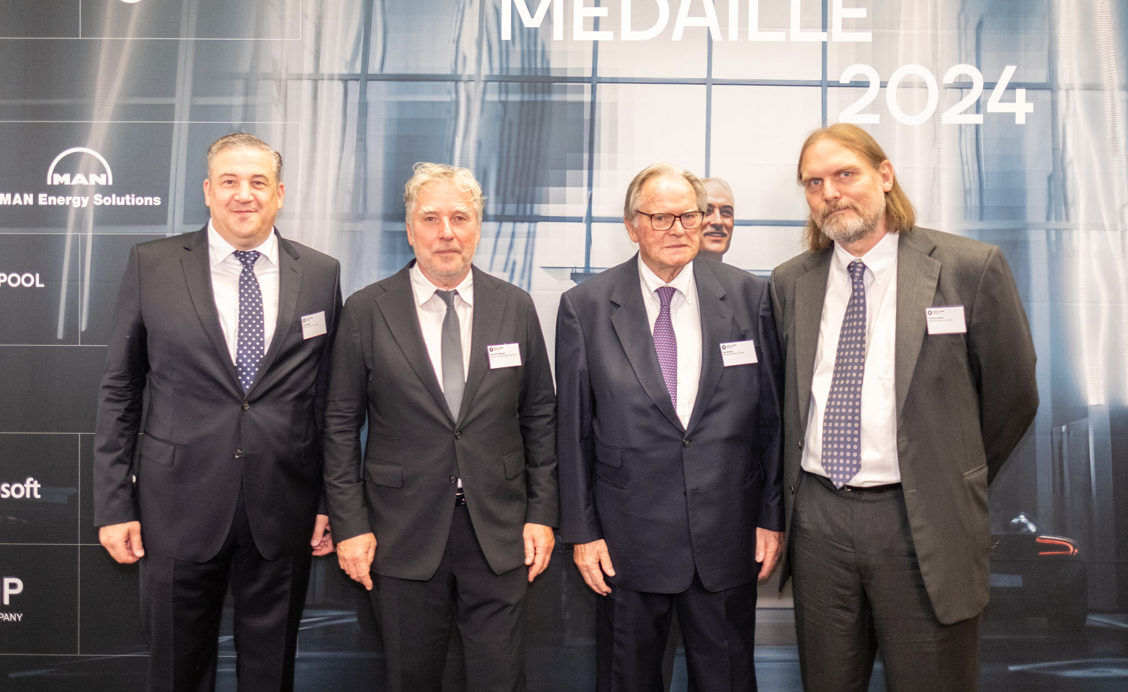 Veit Enders, Prof. Kurt Mehnert, Udo Schütz vor der Sponsorenwand der Dieselmedaille 2024.