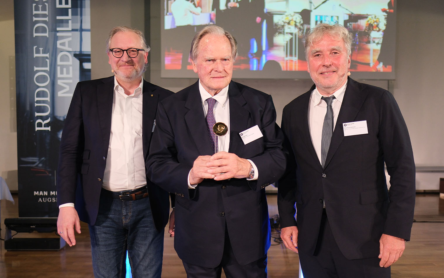 Dr. Alexander Wurzer, Udo Schütz und Prof. Kurt Mehnert auf einem Foto mit der Auszeichnung zur Dieselmedaille 2024.